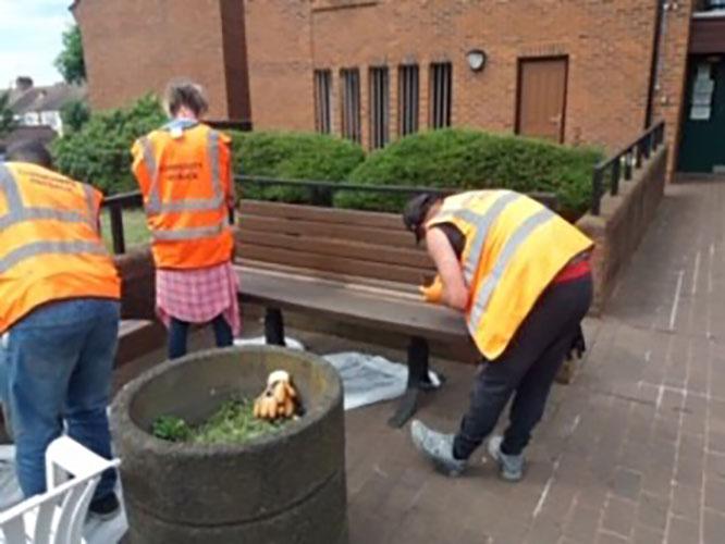 Volunteers painting bench