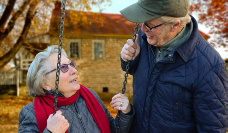 Image of an elderly couple smiling at each other