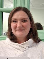 Trudi smiles, wearing a white hoodie jumper