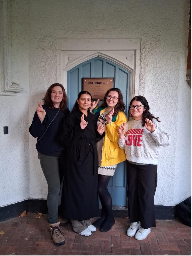 A group of women making the fingers crossed sign