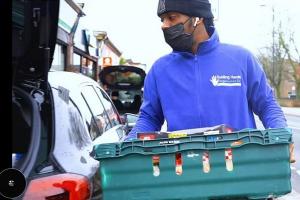 community working carrying a crate of groceries