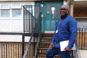 photo of council housing officer standing outside a block of flats