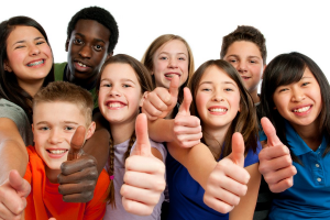 photo of a group of smiling children showing the thumbs up