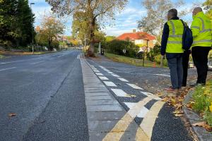Photo of two men in high-vis jackets looking at the new drainage installed on Lower Barn Road.