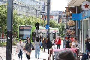 photo of people walking along George Street with a tram in the background
