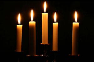 five lit candles on a black background