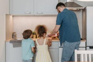 photo of a man and two children in a kitchen