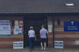 Two people walking into a polling station