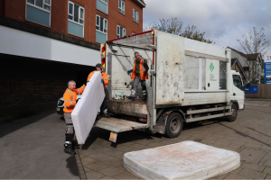 waste contractors loading fly-tipped mattresses onto a van