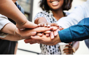 A group of people with their hands on top of each others