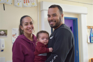 A young smiling couple with their child