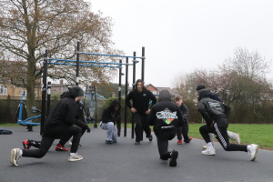 An exercise group stretching at an outdoor gym