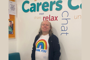 A man stands in front of a Carers display wall