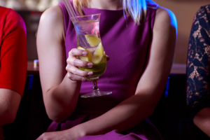 Person holding a drink in a cocktail glass