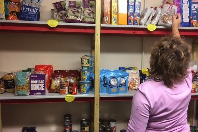 A woman browsing shelves of food at a food stop