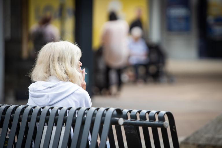 Women sitting on bench smoking