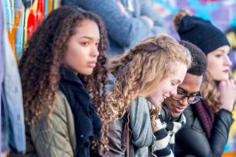 A group of young people sitting and watching an event