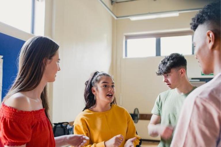 a group of young people in a room talking