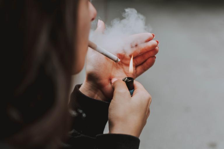 Woman lights a cigarette