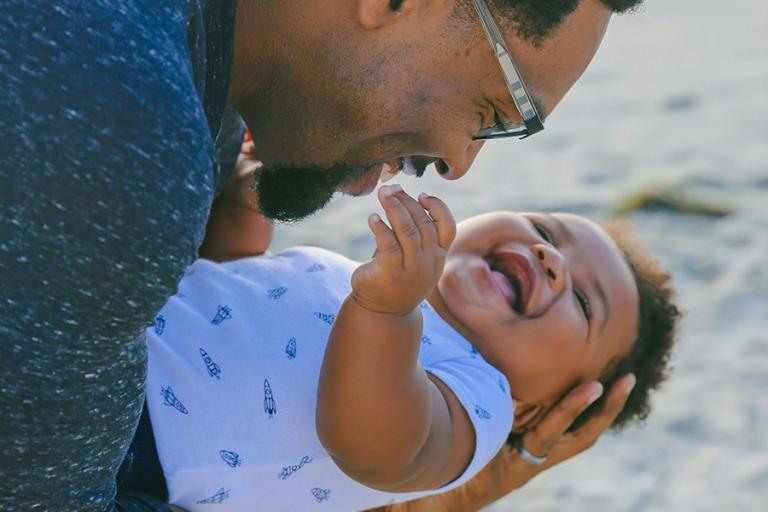 Smiling father holding his baby in his arms