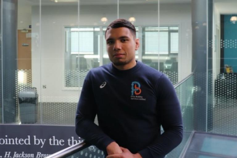 A young man wearing a blue sweatshirt 